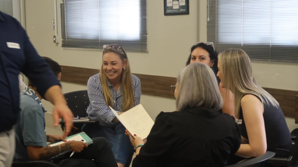Sala com pessoas reunidas durante um workshop sobre autoliderança e gestão comportamental.